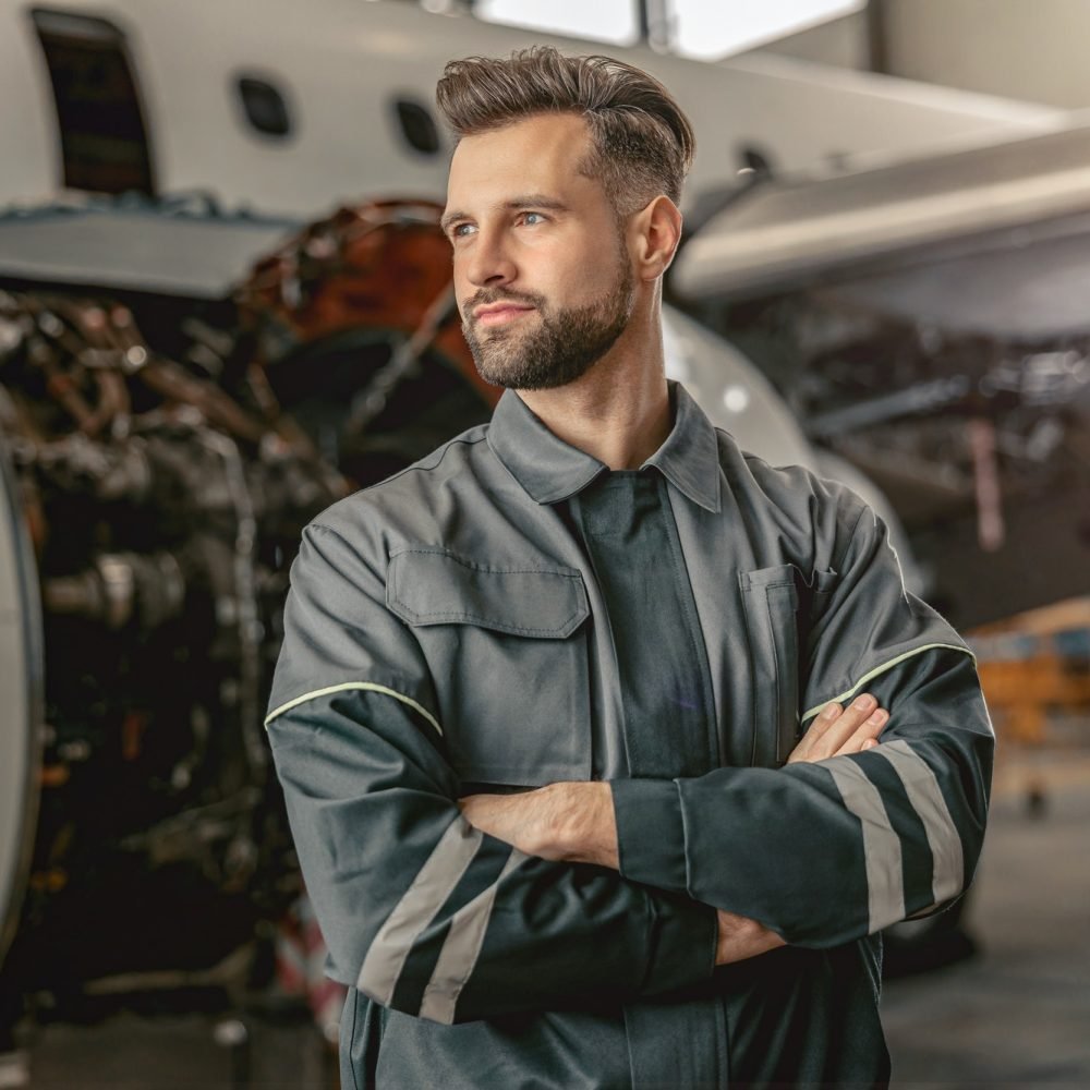 Bearded man aircraft maintenance engineer standing in hangar